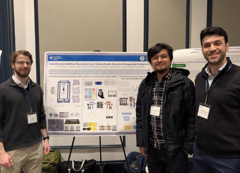 Presenters stand in front of their poster